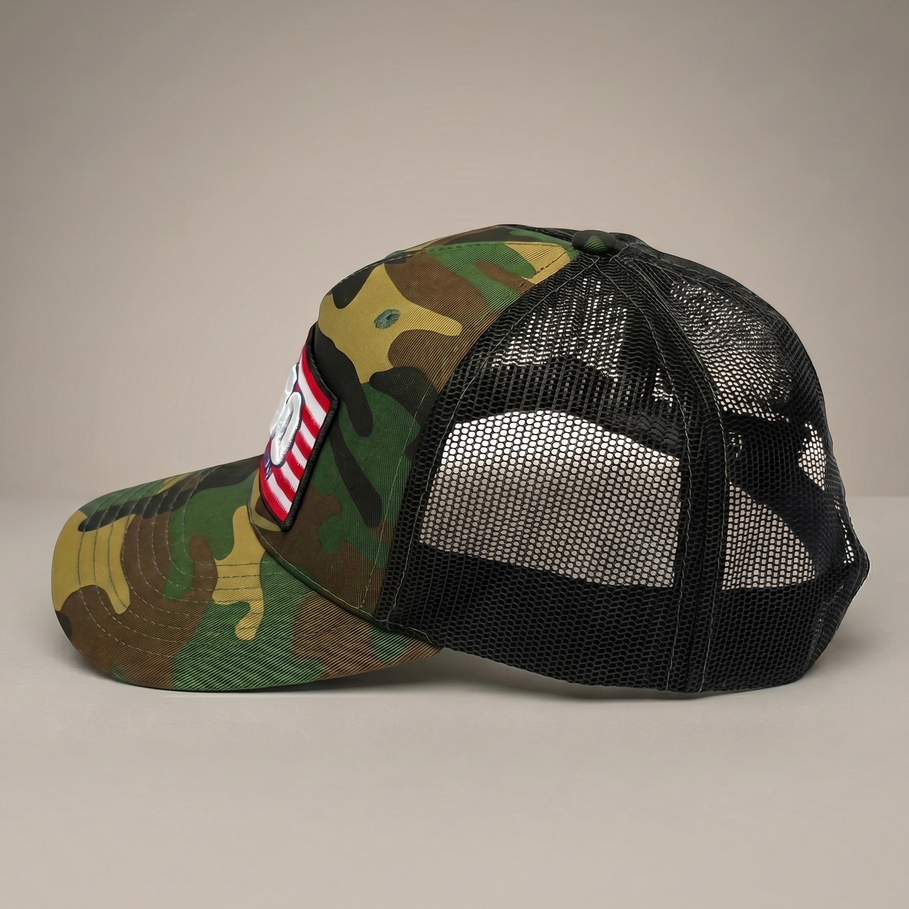 Camouflage trucker cap with mesh back on a beige background American flag 250