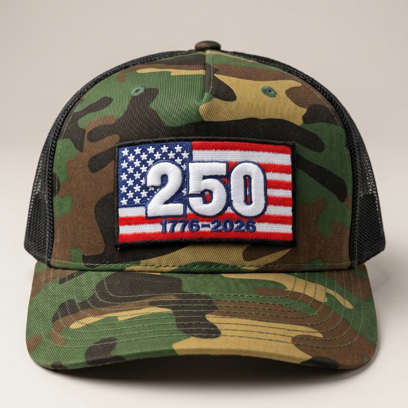 Camouflage cap with a patch featuring the number 250 and American flag design on a white background